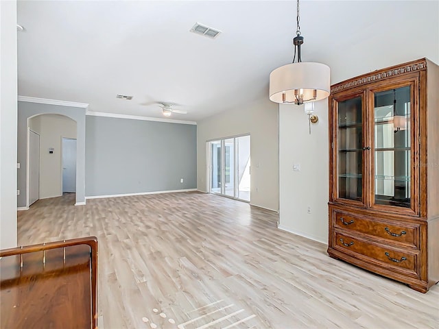 empty room featuring light wood-type flooring, ceiling fan, and crown molding