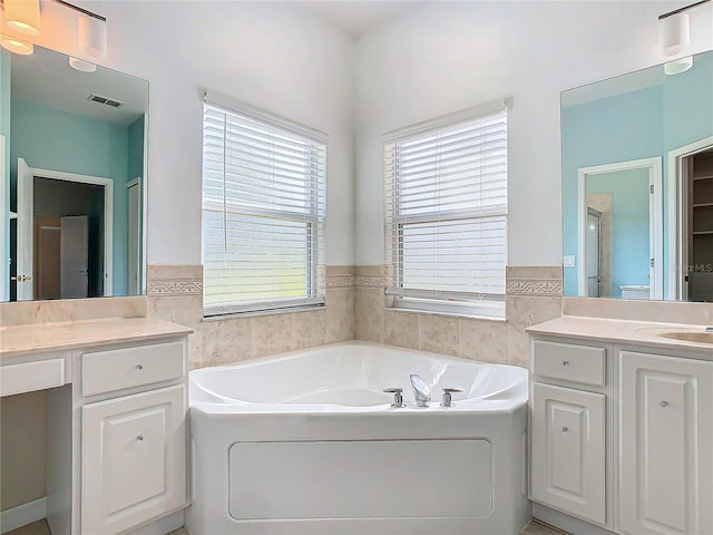 bathroom with vanity, a bathtub, and plenty of natural light