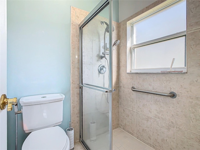 bathroom with toilet and a shower with shower door