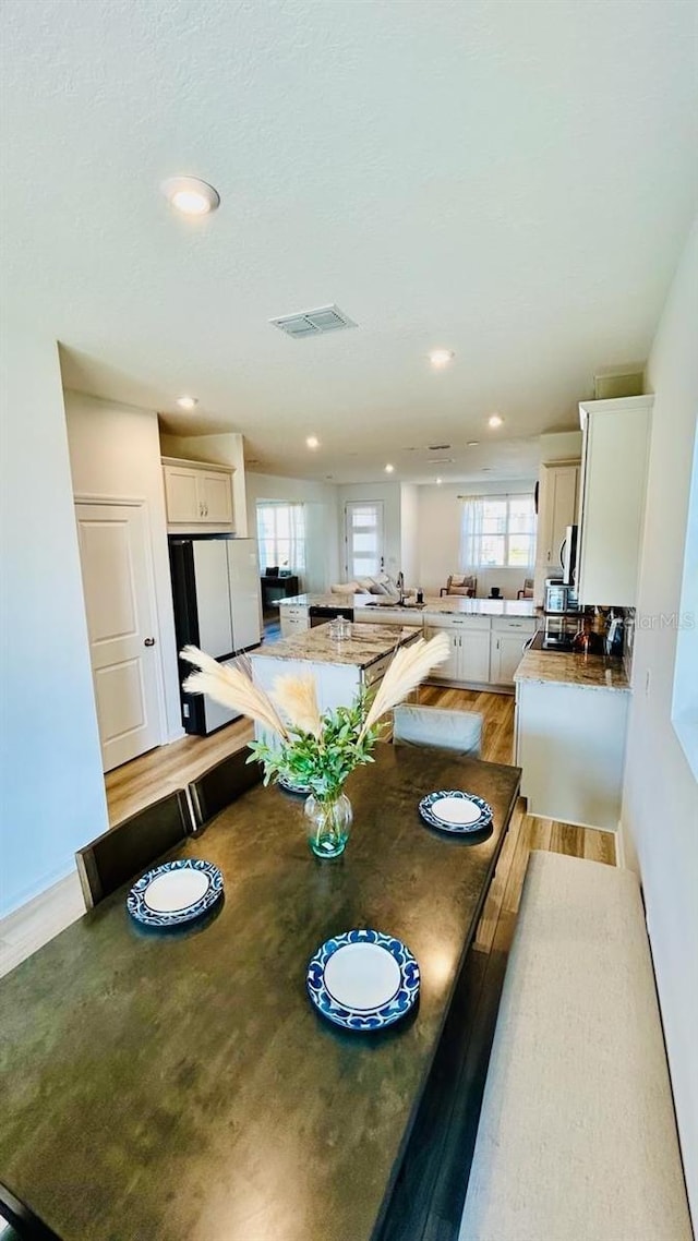 dining room with a textured ceiling and light hardwood / wood-style flooring