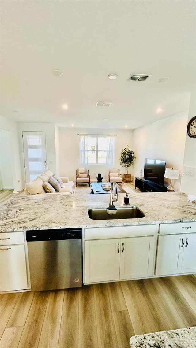 kitchen with sink, white cabinets, stainless steel dishwasher, and light hardwood / wood-style floors