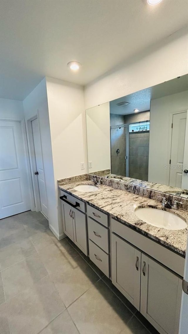 bathroom featuring tile patterned floors, vanity, and a shower with shower door