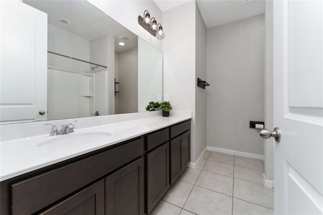 bathroom with walk in shower, tile patterned floors, and vanity