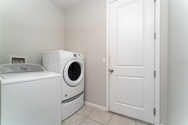 laundry area with light tile patterned flooring and washing machine and clothes dryer