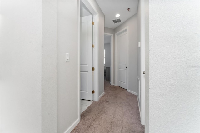 hall with light colored carpet