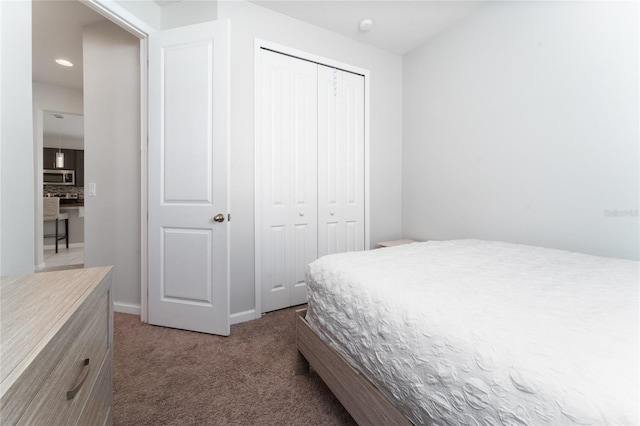 bedroom with dark carpet and a closet