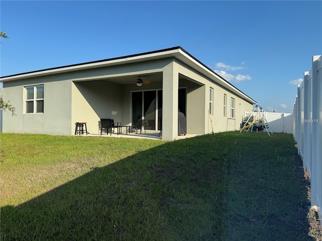 back of house featuring a yard, ceiling fan, and a patio area