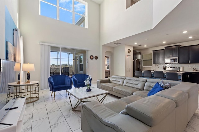 living room featuring a high ceiling and sink