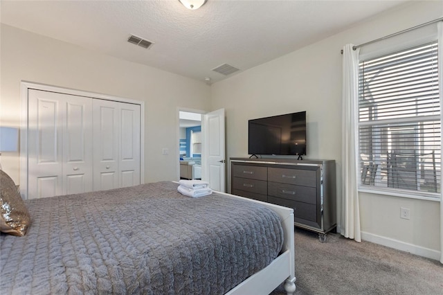 carpeted bedroom featuring a textured ceiling and a closet