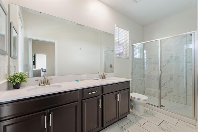 bathroom with vanity, toilet, and a shower with door