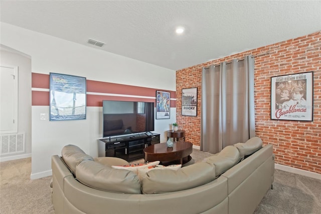 living room featuring light carpet, brick wall, and a textured ceiling