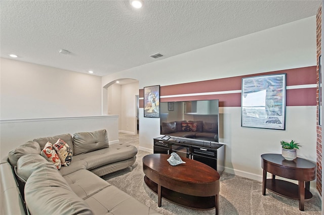 carpeted living room featuring a textured ceiling