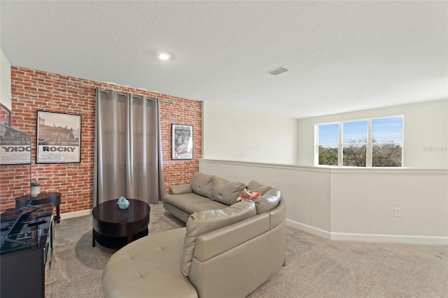 carpeted living room featuring a textured ceiling and brick wall