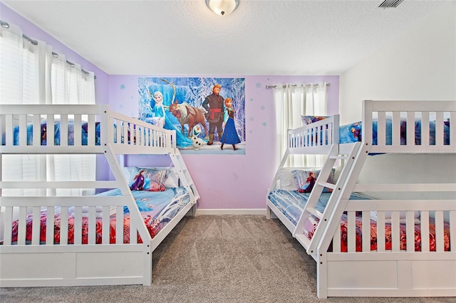 carpeted bedroom featuring a textured ceiling and multiple windows