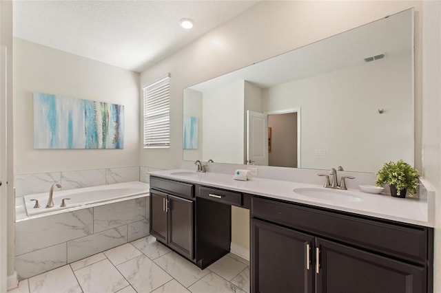 bathroom featuring tiled bath and vanity