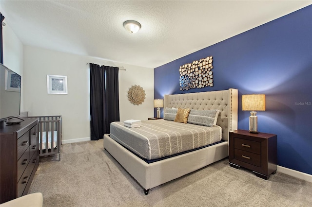 bedroom featuring a textured ceiling and light colored carpet