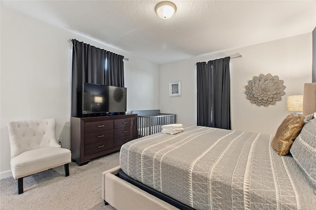 bedroom with light carpet and a textured ceiling