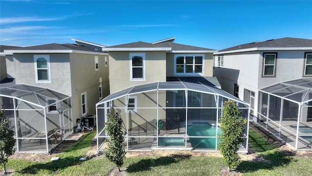 back of property with a yard, a patio area, and a lanai