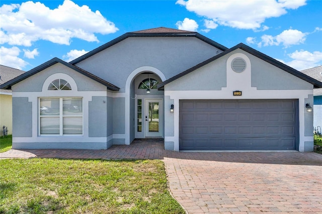 ranch-style house featuring a front yard and a garage