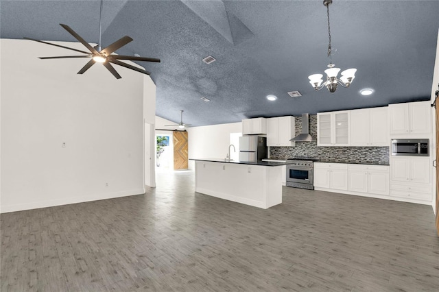 kitchen with wall chimney exhaust hood, backsplash, decorative light fixtures, white cabinets, and appliances with stainless steel finishes