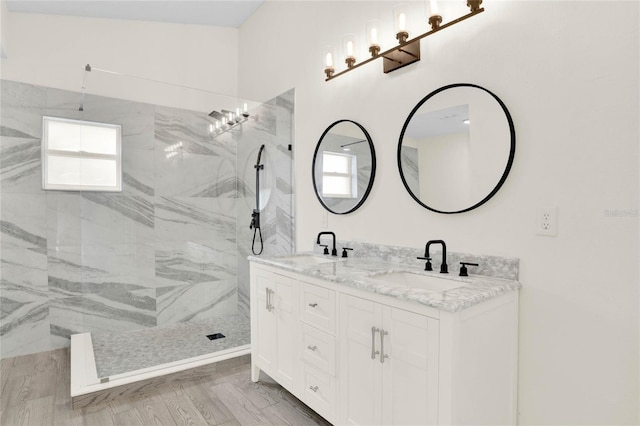 bathroom featuring a tile shower, vanity, and hardwood / wood-style flooring