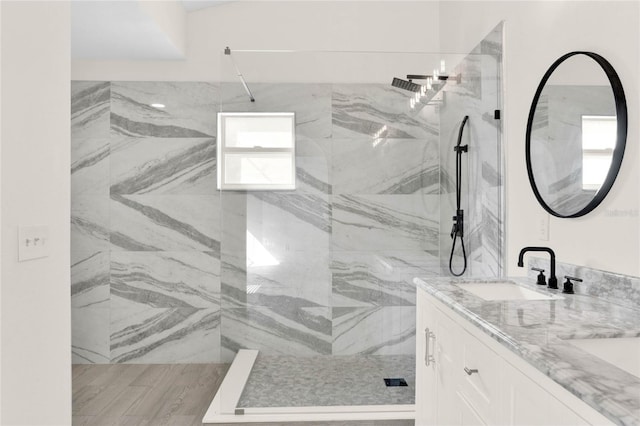 bathroom with tiled shower and vanity