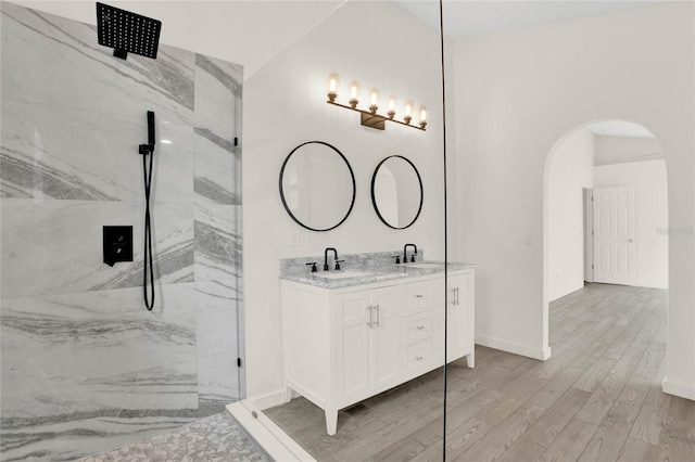 bathroom featuring tiled shower, vanity, and hardwood / wood-style flooring