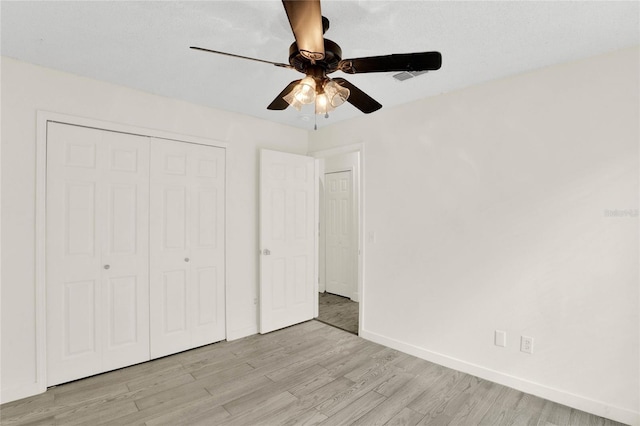 unfurnished bedroom with a closet, ceiling fan, and light hardwood / wood-style flooring