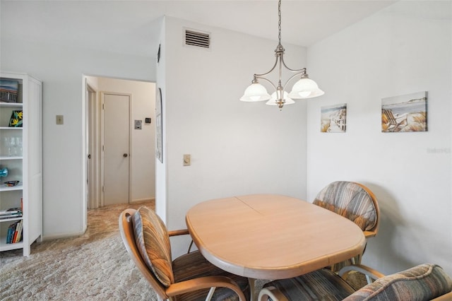 dining room with carpet and a notable chandelier