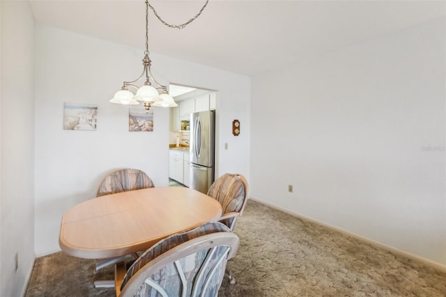 carpeted dining room with a notable chandelier