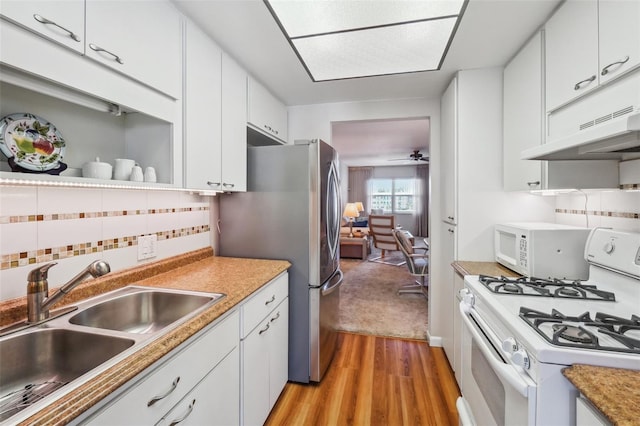 kitchen featuring white cabinetry, sink, white appliances, and light hardwood / wood-style flooring