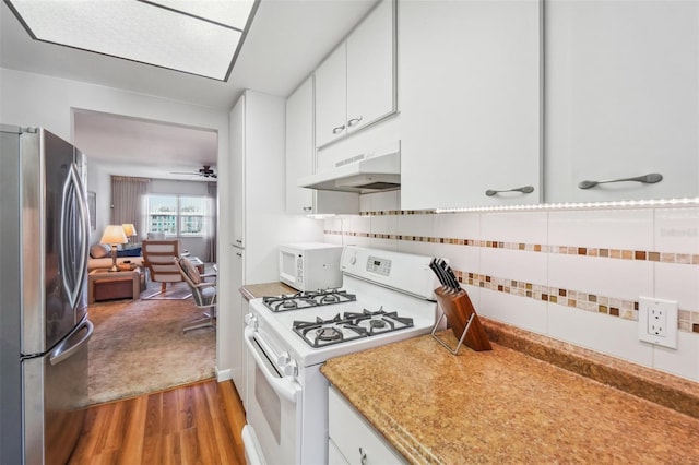 kitchen featuring backsplash, white appliances, dark hardwood / wood-style floors, and white cabinets