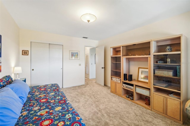 bedroom with a closet and light carpet