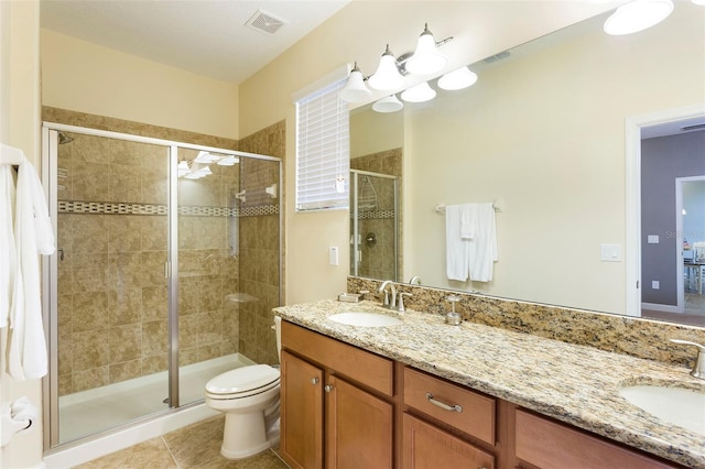 bathroom featuring tile patterned flooring, vanity, toilet, and a shower with shower door