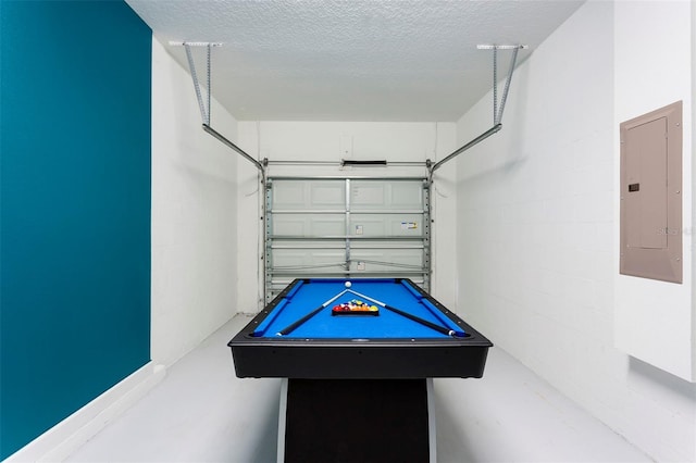 playroom with a textured ceiling, electric panel, concrete floors, and billiards