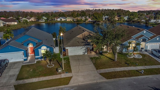 aerial view at dusk featuring a water view