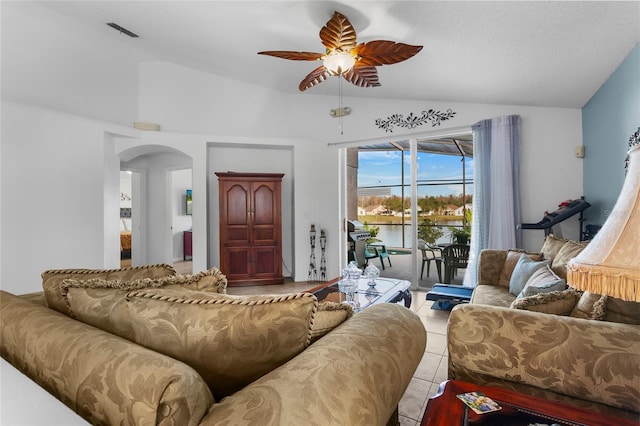 tiled living room featuring ceiling fan and vaulted ceiling