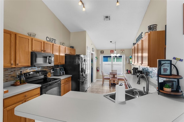 kitchen featuring sink, kitchen peninsula, a chandelier, light tile patterned floors, and black appliances