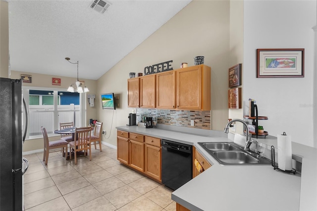 kitchen featuring stainless steel refrigerator, dishwasher, sink, hanging light fixtures, and vaulted ceiling