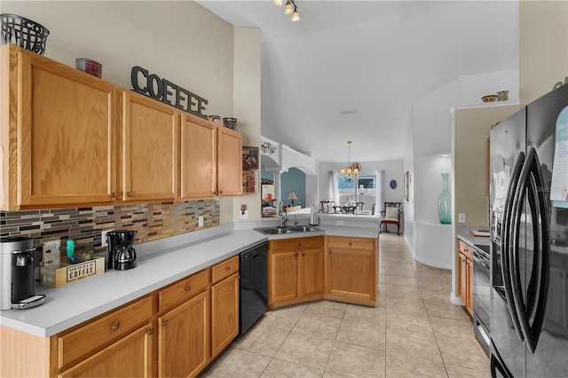 kitchen featuring kitchen peninsula, appliances with stainless steel finishes, sink, pendant lighting, and a notable chandelier