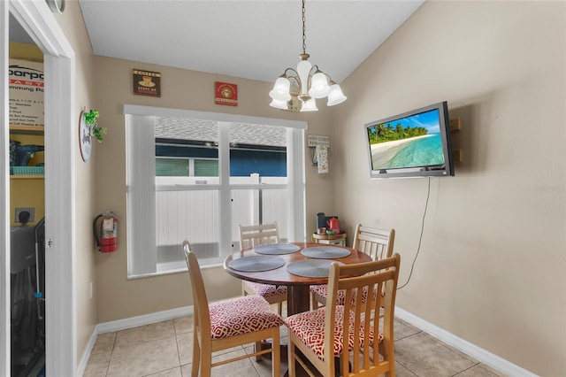 tiled dining room featuring vaulted ceiling and a notable chandelier