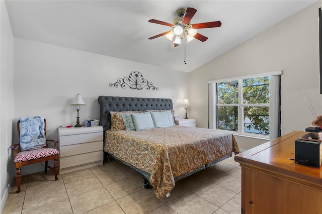 bedroom with ceiling fan, light tile patterned flooring, and lofted ceiling