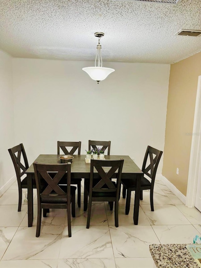 dining space featuring a textured ceiling