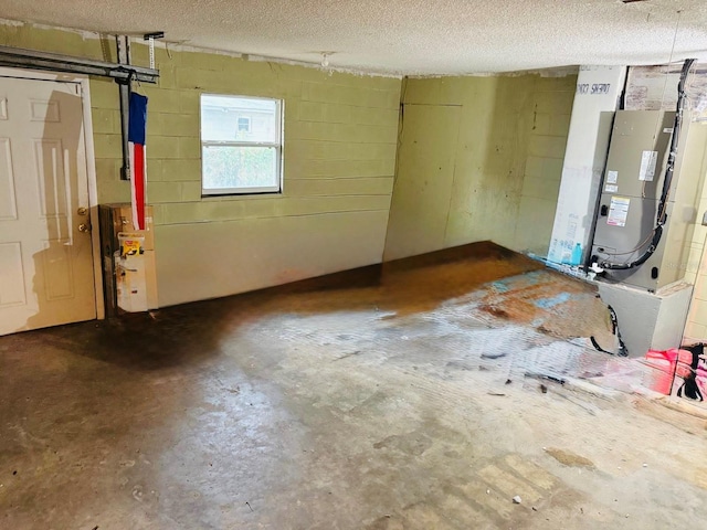 basement featuring a textured ceiling and heating unit