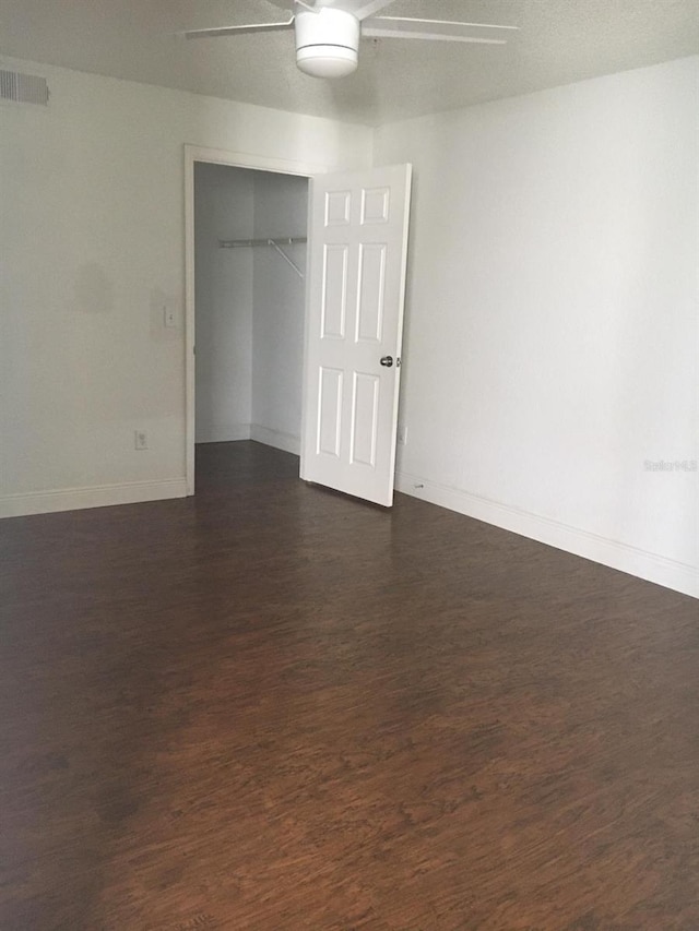 spare room featuring ceiling fan and dark hardwood / wood-style floors