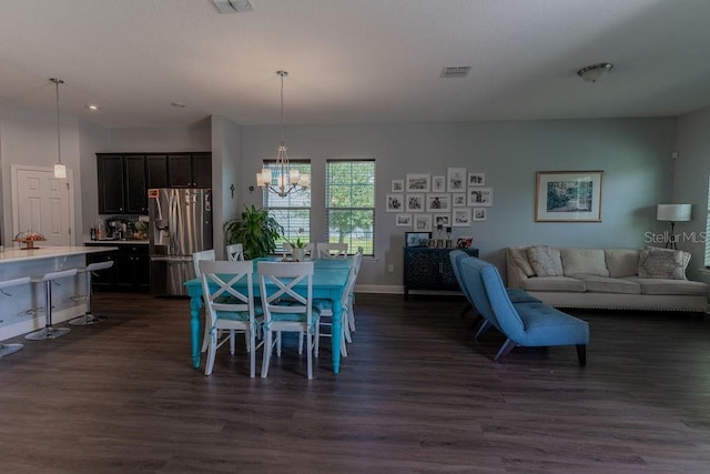 dining space featuring dark hardwood / wood-style flooring and a chandelier