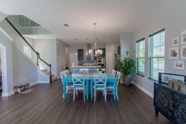 dining area with dark wood-type flooring and a chandelier