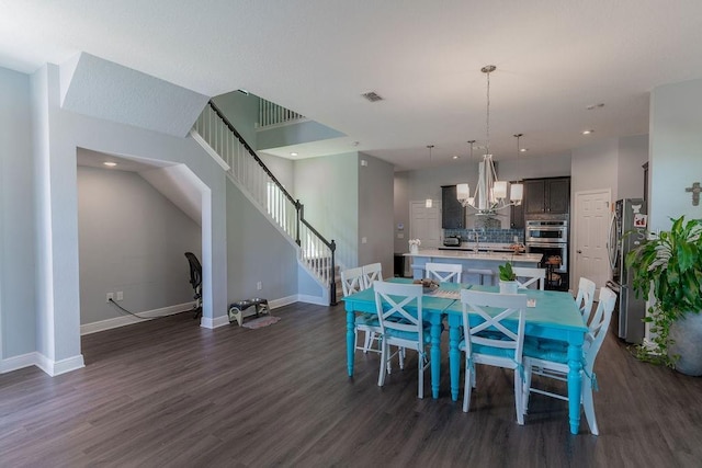 dining space with dark hardwood / wood-style floors and an inviting chandelier