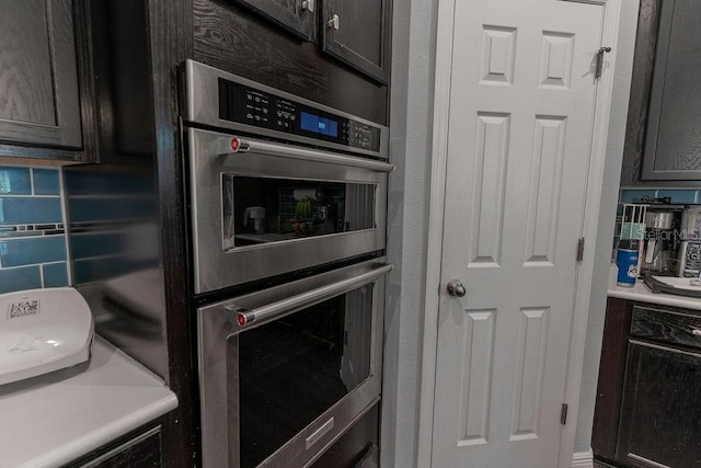 kitchen featuring backsplash, stainless steel double oven, and dark brown cabinetry