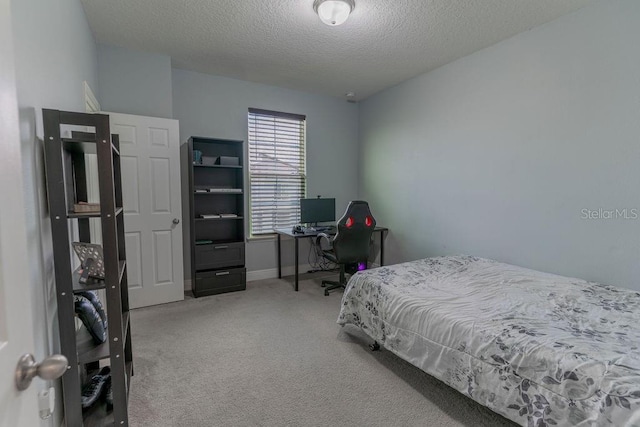 bedroom with a textured ceiling and carpet flooring